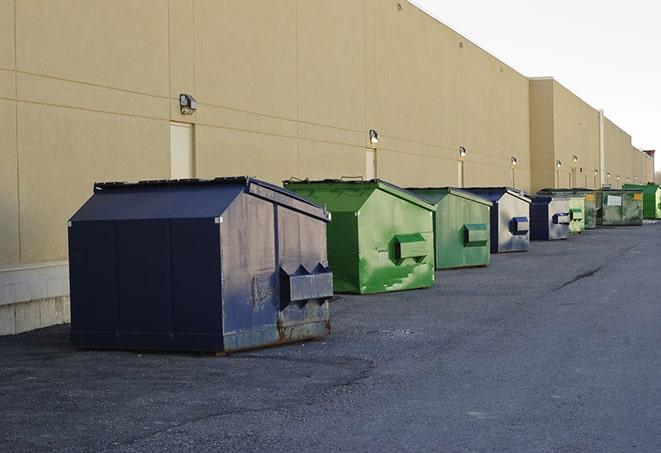 a group of construction workers taking a break near a dumpster in Bailey